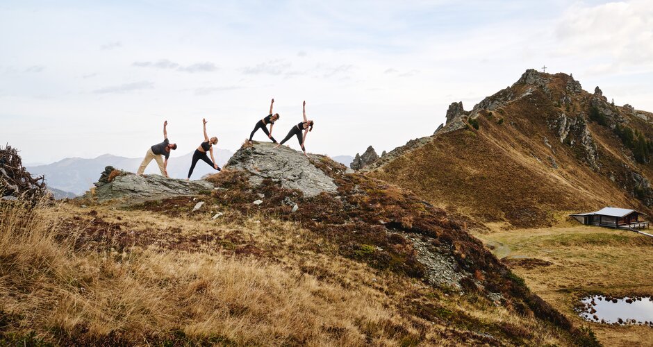 4 people stand on a rock and do yoga | © Gasteinertal Tourismus GmbH, Michael Königshofer