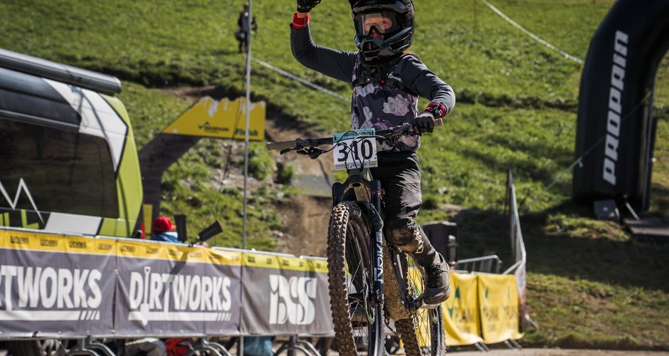 Young mountain biker with helmet celebrates at finish line of a race on Planai mountain. | © Sebastian Gruber