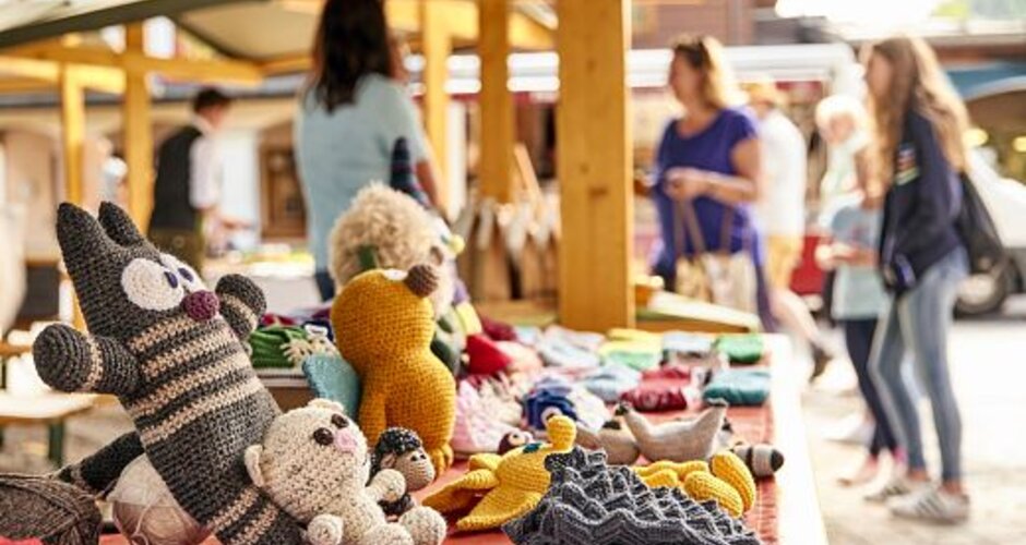 Self-crocheted soft toys sit next to each other on a red tablecloth | © Wagrain-Kleinarl Tourismus