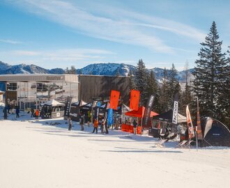 Testzelte und Markenstände mit Ski und Snowboards vor dem Absolut Park Gebäude im Shuttleberg | © Shuttleberg