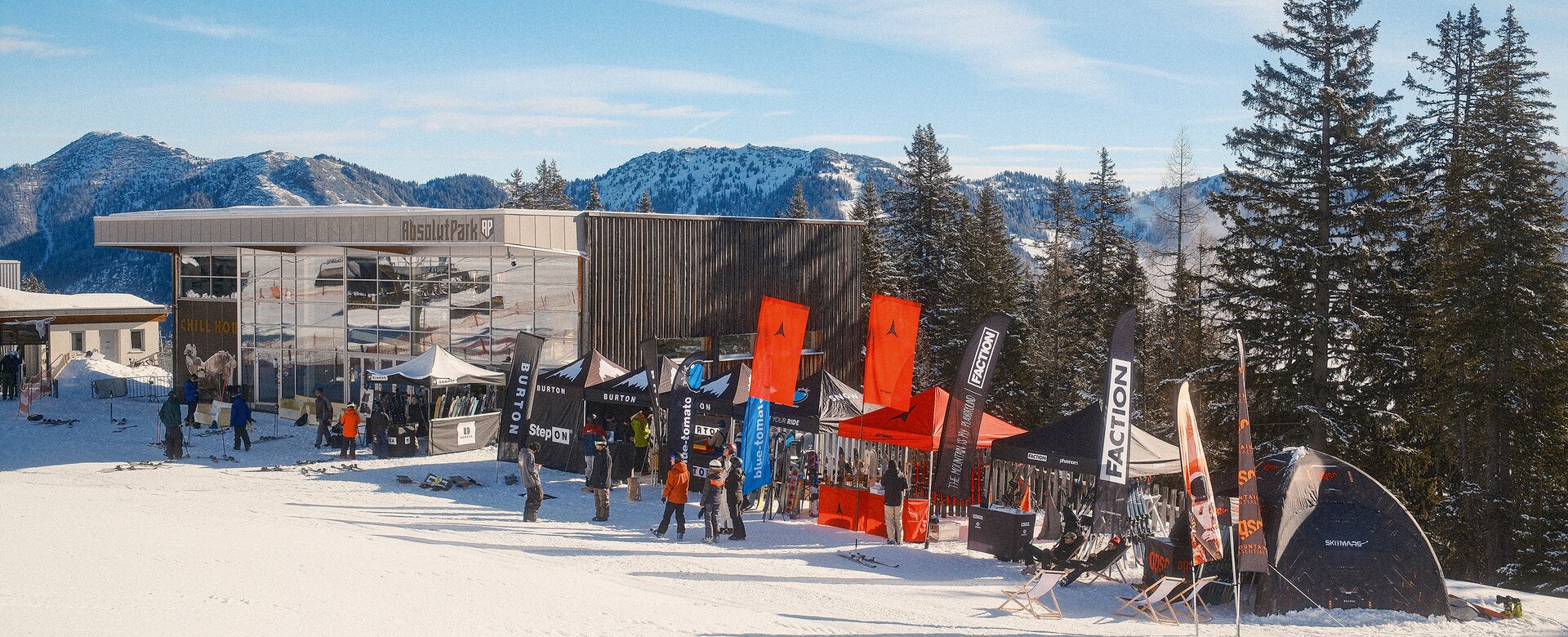 Test tents and brand booths with skis and snowboards in front of Absolut Park building at Shuttleberg | © Shuttleberg