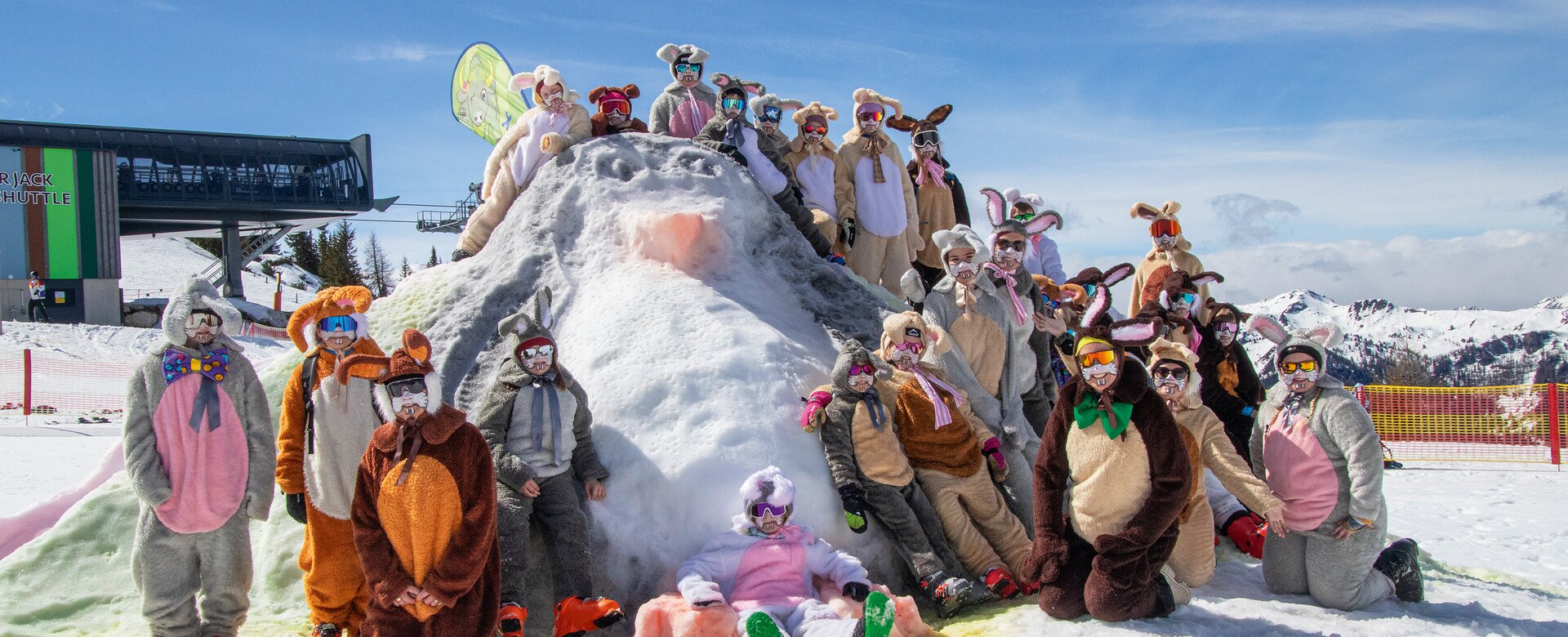 Group of skiers in Easter bunny costumes posing on snowy hill in sunny weather at ski resort area | © Shuttleberg