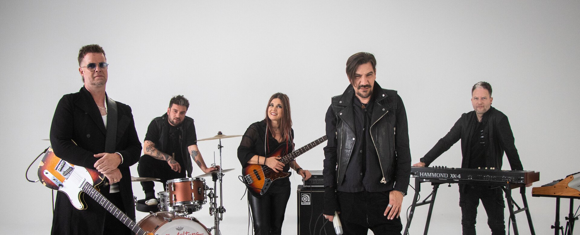Five-member band with guitar, drums, bass, keyboard and microphone in white photo studio with equipment | © Alle Achtung