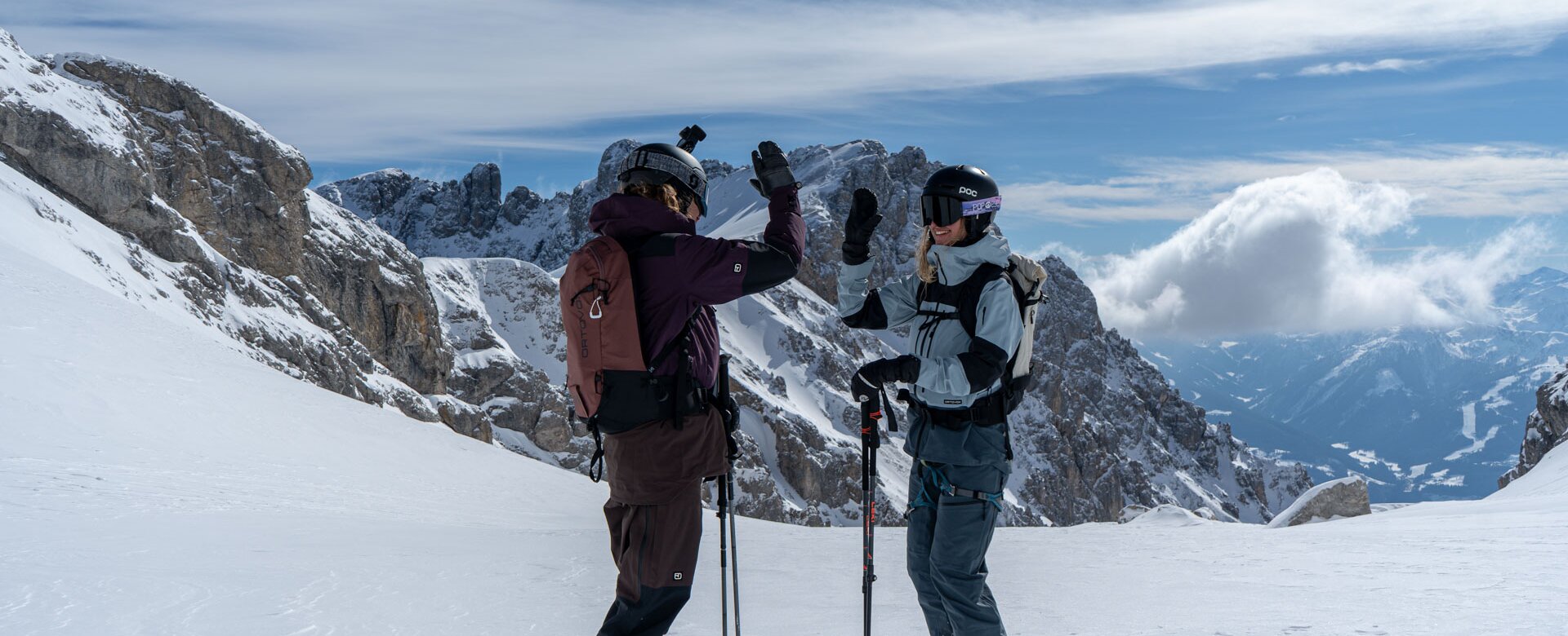 Two skiers high-five each other in the snow on Dachstein Glacier slope | © Josh Absenger