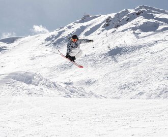 Skier is in the air and touches the ski with your right hand | © Q-Parks Hannes Mautner