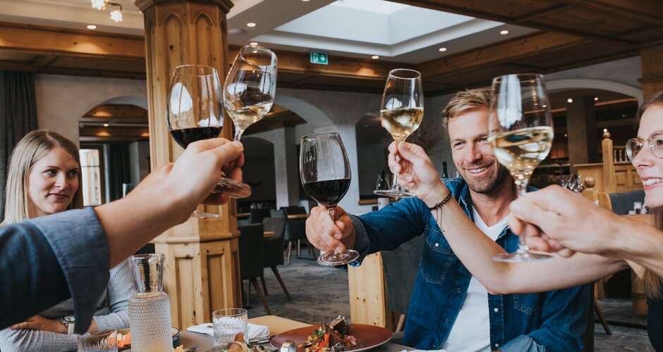 Group toasting with red and white wine at Hotel Tauernhof restaurant