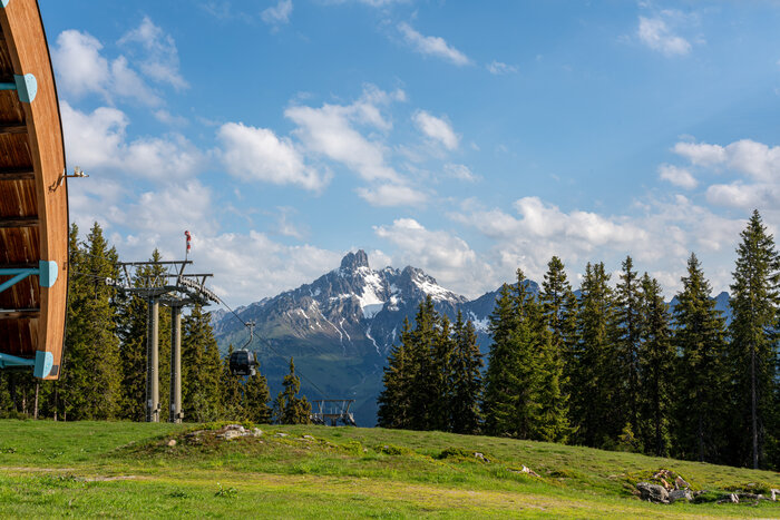 Papageno-Gondel vor grüner Alm und dem markanten Doppelgipfel Bischofsmütze bei Filzmoos | © Coen Weesjes