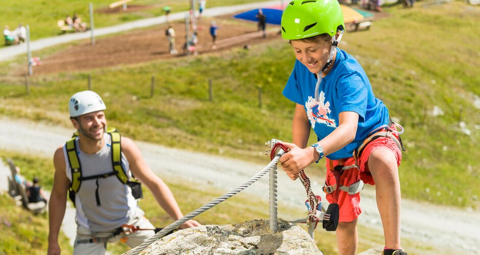 Boy climbs with gear on rope, father belaying him at Schlossalm climbing park | © Skigastein, Fotoatelier Gerhard Wolkersdorfer