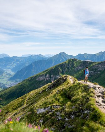 Wanderer auf einem Gratweg am Stubnerkogel mit weitem Blick über das grüne Gasteinertal und die umliegenden Berggipfel | © Gasteinertal Tourismus GmbH, Christoph Oberschneider