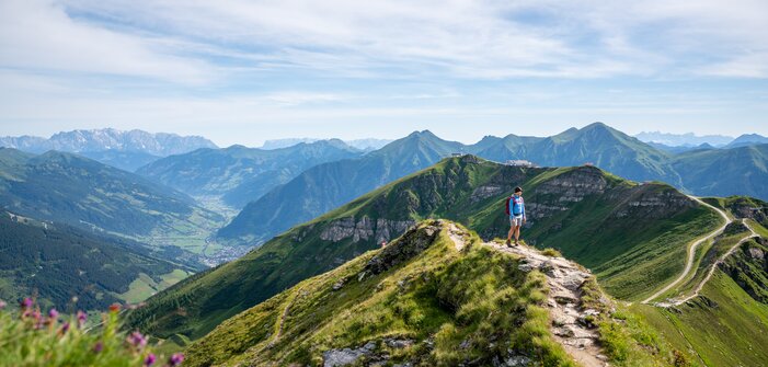 Wanderer auf einem Gratweg am Stubnerkogel mit weitem Blick über das grüne Gasteinertal und die umliegenden Berggipfel | © Gasteinertal Tourismus GmbH, Christoph Oberschneider