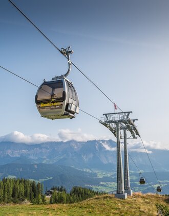 Preunegg Jet cable car on Reiteralm gliding above summer landscape with scenic view of Enns Valley and Dachstein mountains | © Lorenz Masser