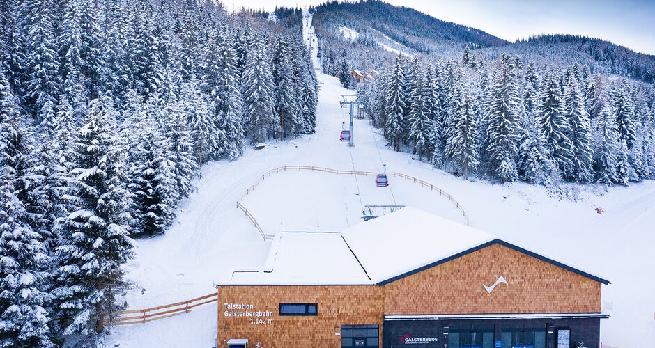 Base station of Galsterberg gondola with snow-covered trees in the background. | © Josh Absenger