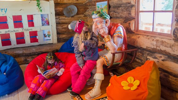 Children in winter clothes reading and playing next to a Gallic figure at Galsterberg ski resort. | © Christine Höflehner 