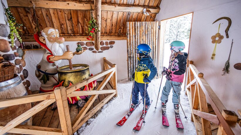 Two kids in ski clothes look at a magic potion station at Galstiland, Galsterberg. | © Mirja Geh