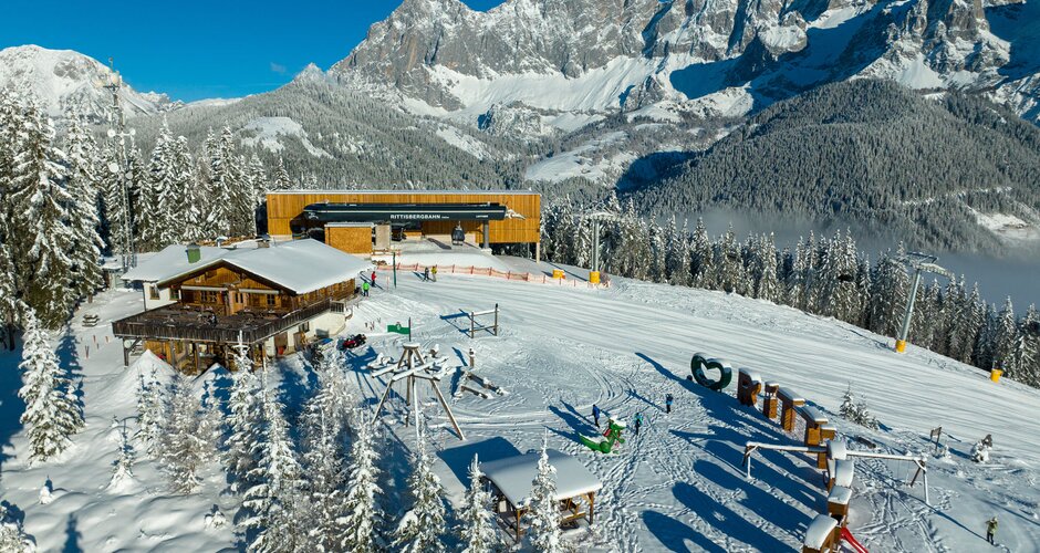 Aerial view of the snow-covered mountain station of the Rittisbahn and a ski hut with playground