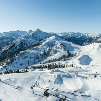 Snowpark Shuttleberg mit geshapten Pisten, Liften und verschneiten Bergen im Hintergrund | © Shuttleberg