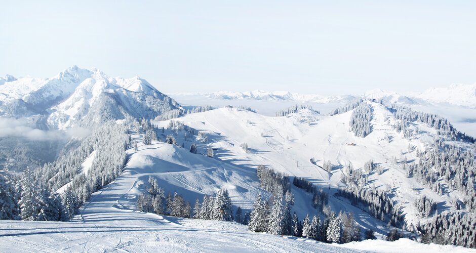 Schneereiche Pistenlandschaft mit Blick auf die umliegenden schneebedeckten Berge mit strahlend blauem Himmel | © Snow Space Salzburg