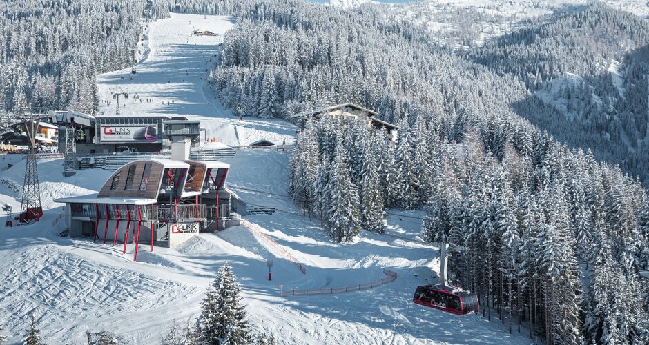 G-LINK Wagrain Seilbahn mit verschneiten Skipisten, Wald und Bergen im Hintergrund | © Trampitsch