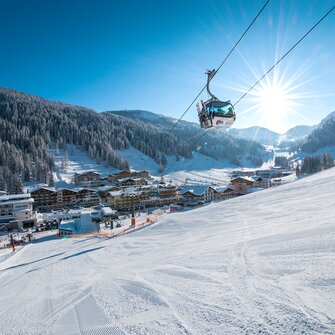 Gondelbahn im Zauchensee Tal mit verschneiten Hängen, Pulverschnee und Sonne im Hintergrund