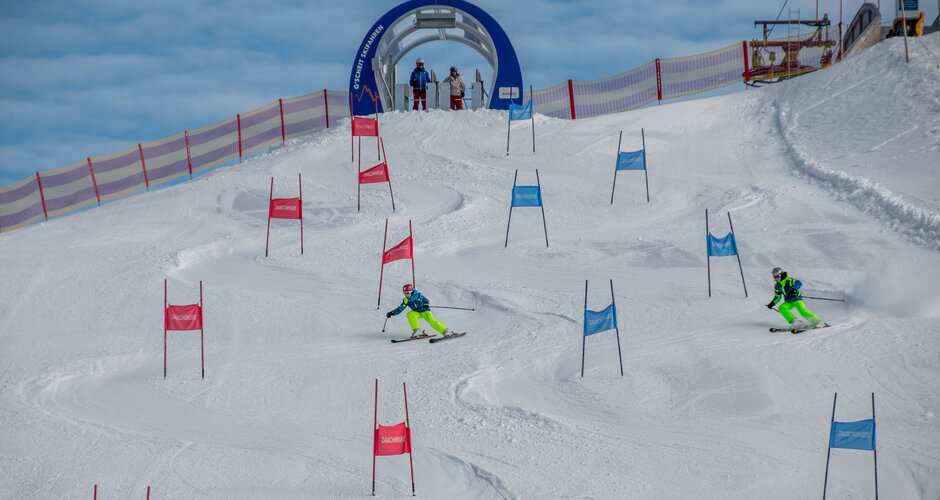Zwei Skifahrer im Parallelslalom zwischen roten und blauen Toren in Zauchensee