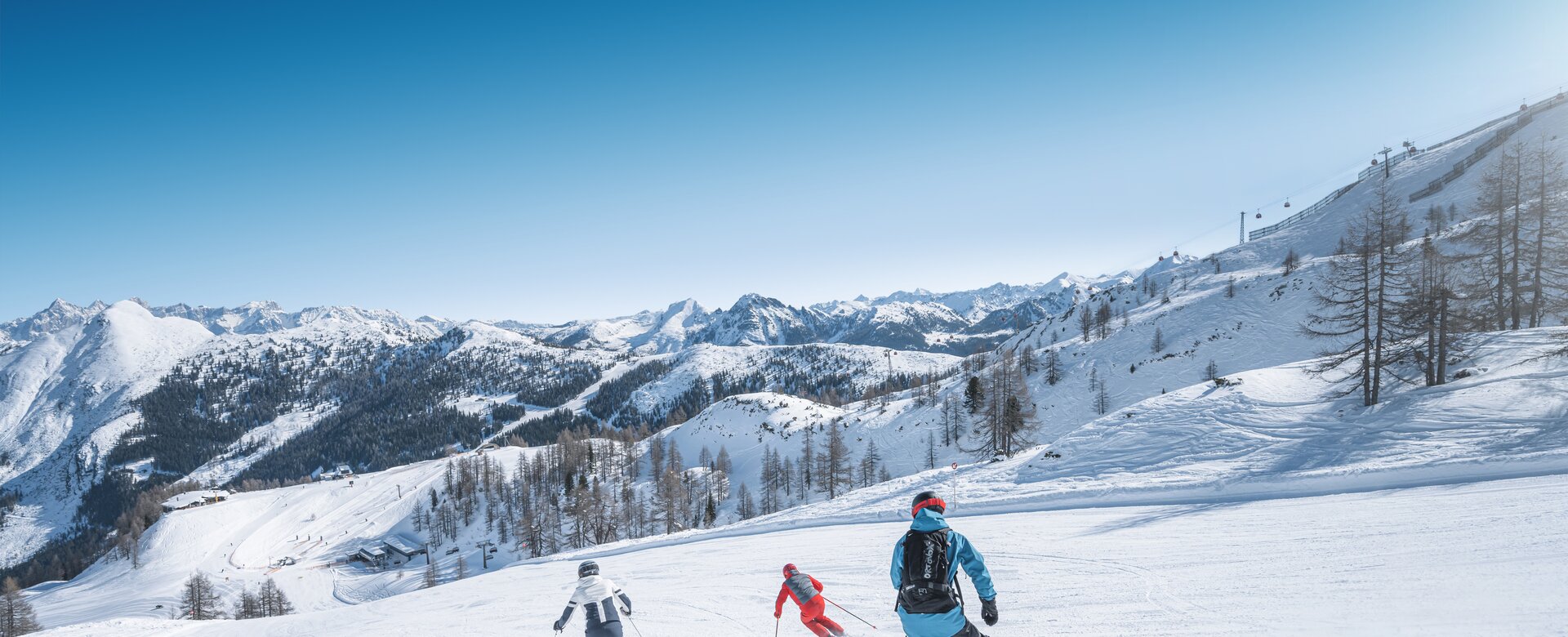 Three winter sports enthusiasts skiing and snowboarding together on the slope
