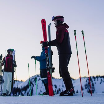 Four skiers stand on a snowy slope under a violet sky. | © Ski amadé