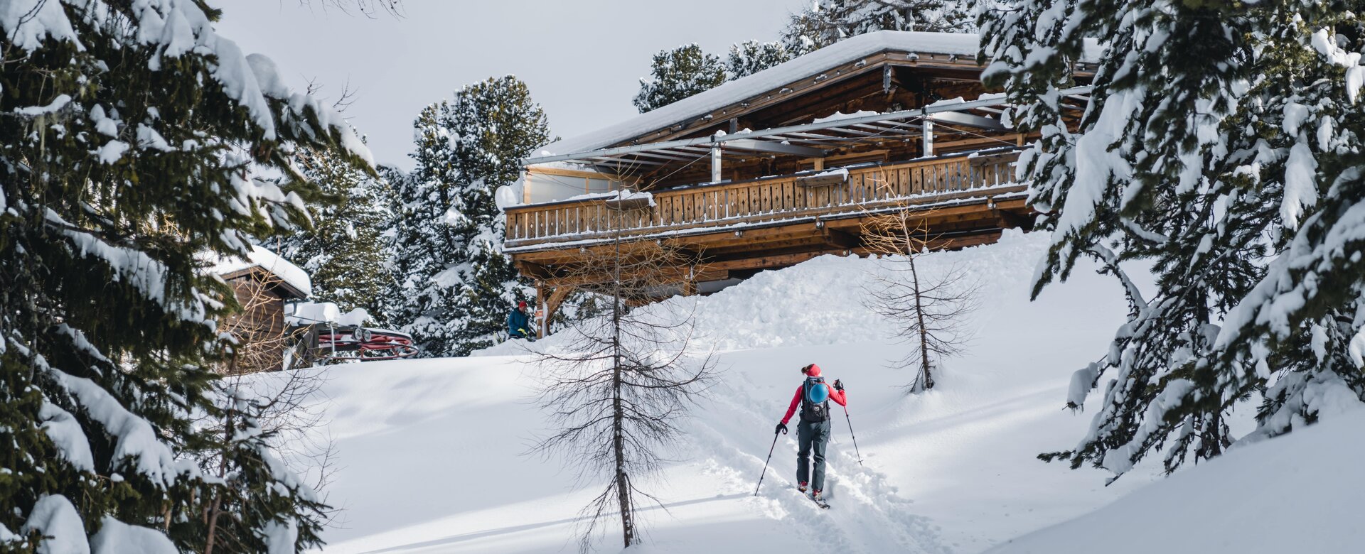 Ski tourer approaches Graukogelhütte on snowy slope through forested winter landscape | © Gasteinertal Tourismus GmbH, Christoph Oberschneider