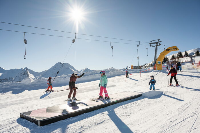 Kinder und Erwachsene fahren durch die Funslope mit Wellenbahn im Skigebiet Großarltal | © TVB Großarltal / Lorenz Masser