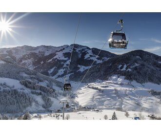 Gondeln der Sonnbergbahn fahren über verschneite Hänge bei Maria Alm in der Wintersonne | © www.felsch-foto.at