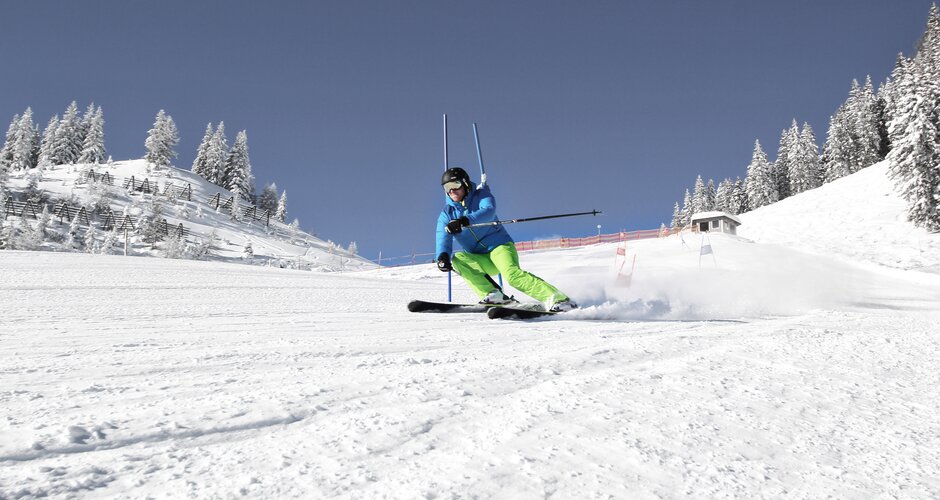 Skier skis down the race track past a gate