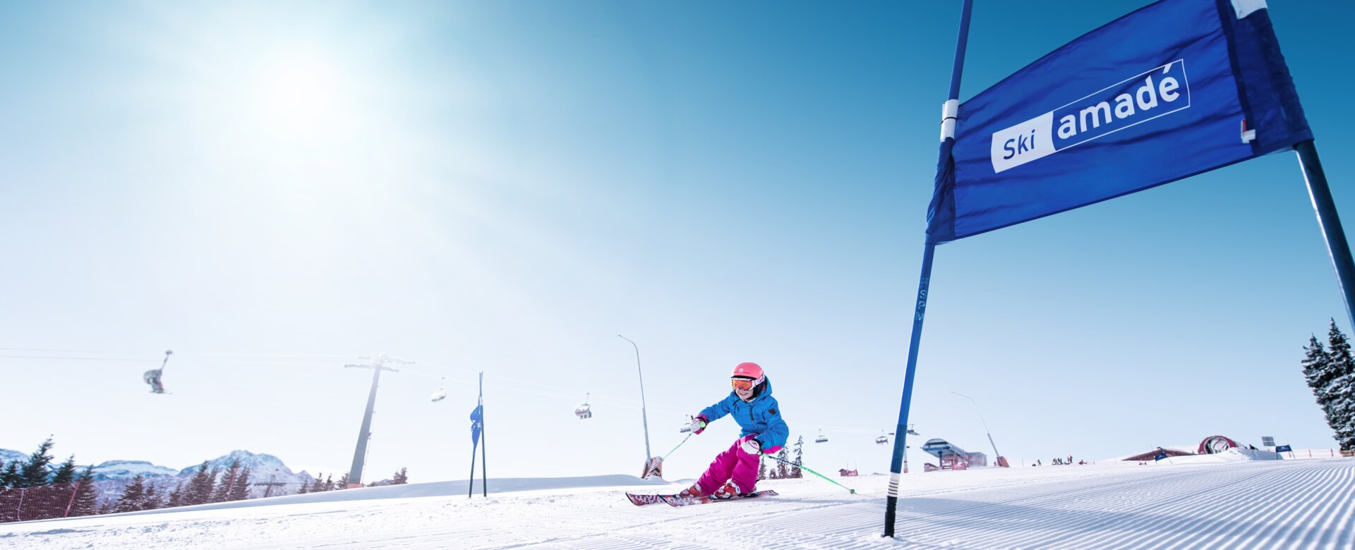 Kind fährt auf Skiern in die kurve hinein, damit es an dem blauen Tor vorbeifahren kann