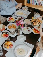 Vier Personen frühstücken mit Brot, Obst, Aufschnitt, Omelett und Waffeln | © Nadia Jabli