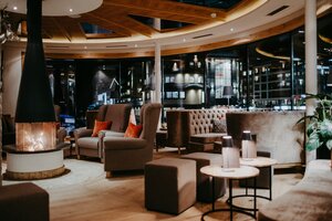 Moderne Hotellounge mit Sesseln, Sofas, Tischen und offenem Kamin bei Nacht | © Nadia Jabli