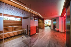 Moderne Saunalandschaft mit Holzsauna, Glasfront und gemütlichem Ruhebereich | © Nadja Nabli