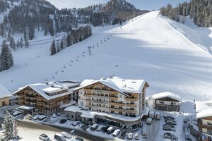 Hotel Salzburger Hof mit Parkplätzen vor breiter Skipiste und Sessellift | © Lorenz Masser