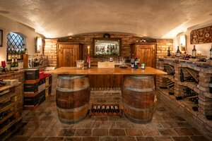 Weinkeller mit Holzfässern, Weinregalen aus Ziegeln, Kerzen und Flaschen