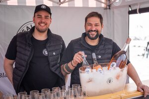 Zwei Männer hinter einem Stand mit Rosalia DAC Roséwein in Eiskübel und mehreren Weingläsern