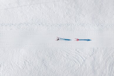 Zwei Langläufer gleiten auf präparierter Loipe im Großarltal durch weite verschneite Winterlandschaft | © Gipfelfieber