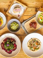 Mehrere angerichtete Speisen mit Brot, Suppe, Salat und Dessert liegen auf einem rustikalen Holztisch. | © Hochkönig Tourismus GmbH