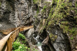 Holzsteg entlang der Liechtensteinklamm über einer engen Felsenschlucht mit Bach und bewachsenen Steilwänden. | © Walter Oczlon