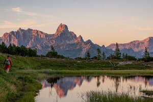 Hiker at Gerzkopf near Eben im Pongau with pond and Dachstein glowing in evening light | © TVB Eben - Nina Kraxner