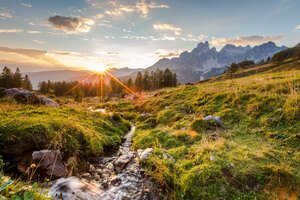 Sonnenaufgang über einem plätschernden Gebirgsbach mit grüner Wiese und der Bischofsmütze im Hintergrund bei Filzmoos | © CoenWeesjes | Filzmoos Tourismus