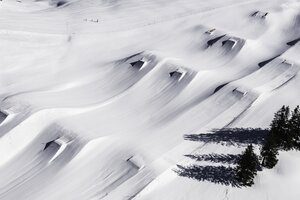 Drohnenbild des Kings Park Hochkönig mit frischem Powder, geshapten Kickern, Rails und markanten Baumschatten im Schnee.